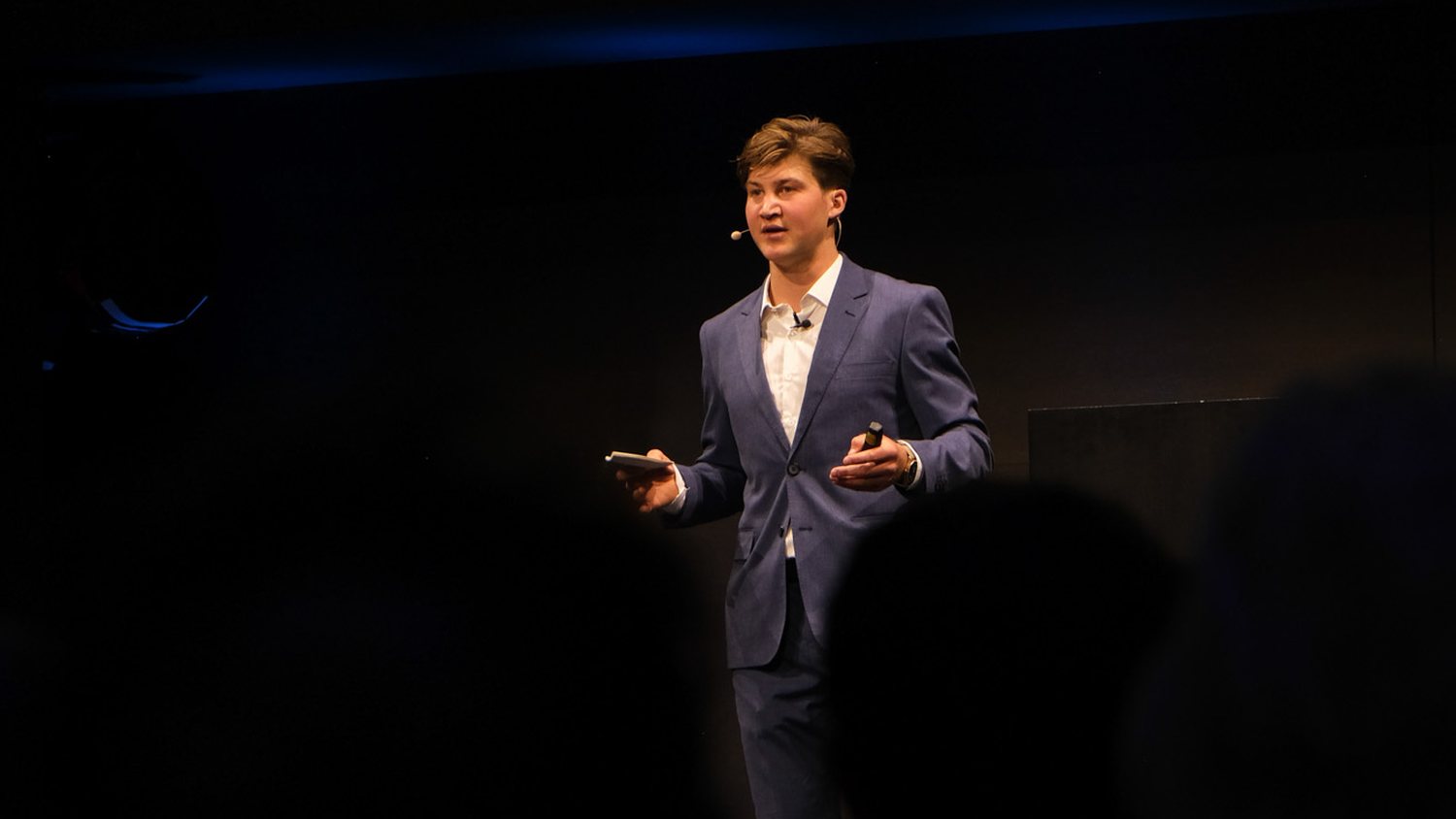 David Hablützel im Anzug auf der Bühne bei Deloitte Schweiz
